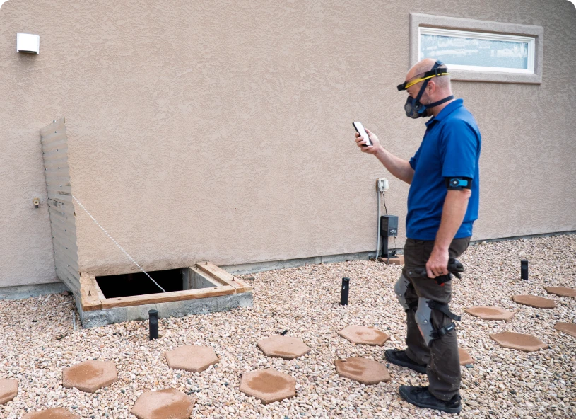 Worker in blue shirt using phone outdoors