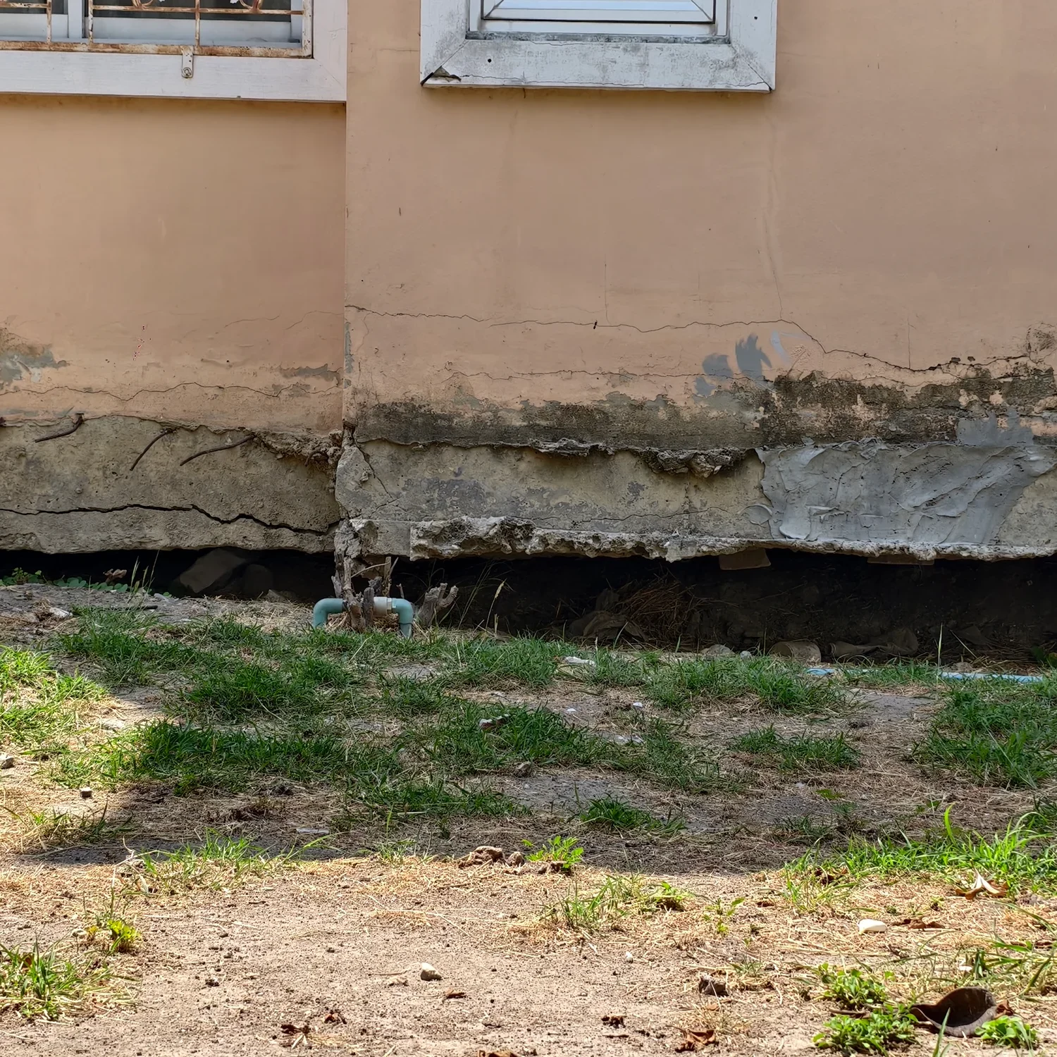 Cracked house foundation with visible damage.