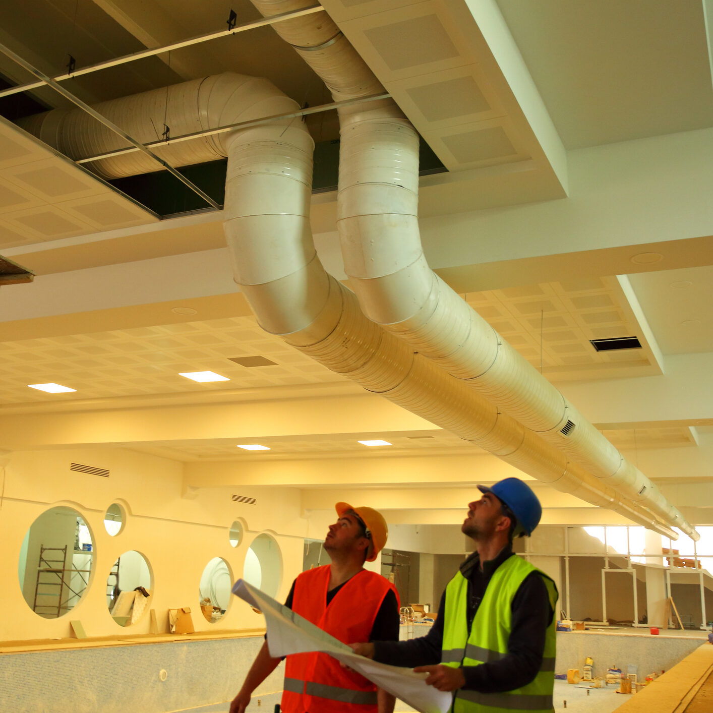 Workers assessing ventilation system installation